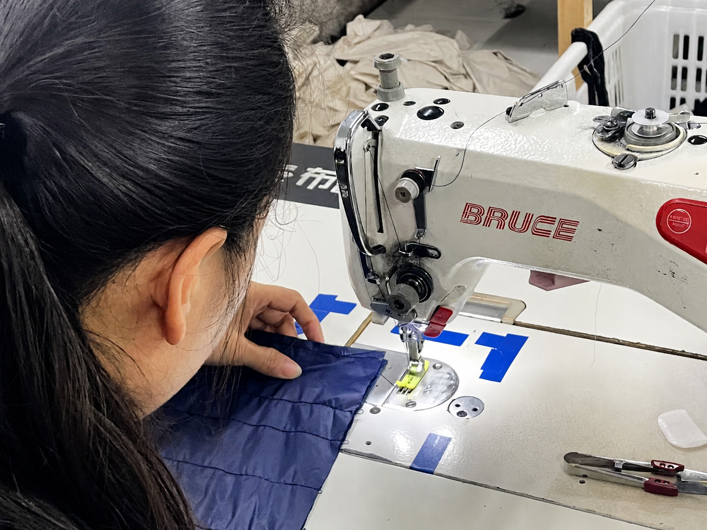 Sample room specialist sewing a garment panel on an industrial machine